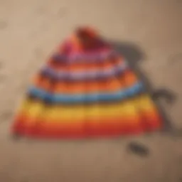 A vibrant beach towel changing poncho laid out on sandy beach