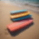 Colorful foam body boards arranged on a sandy beach