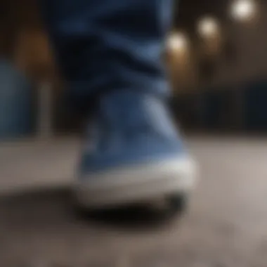 A close-up of dark blue Vans sneakers on a skateboard.