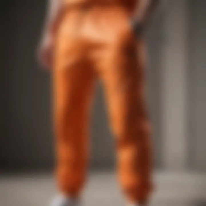 Close-up of the fabric and design details of orange joggers