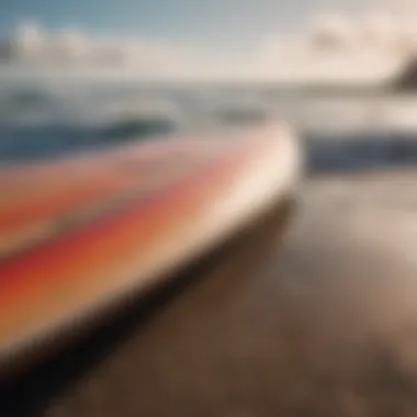 A close-up of a surfboard resting on the beach with waves in the background.