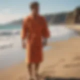 A vibrant towelling surf robe displayed on a sandy beach.